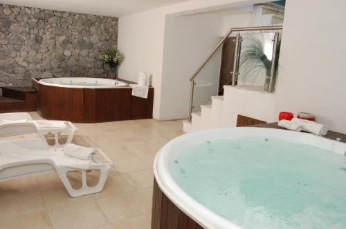 a large bathroom with a tub and a bath tub at Careyes Villa de Mar & Spa in Mar de las Pampas