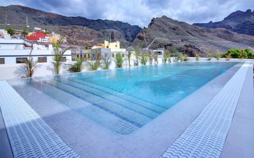 a large swimming pool with mountains in the background at Alse Homes Adeje in Adeje