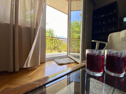 a kitchen with a window and two glasses on a counter at Vila Vidak in Mojkovac