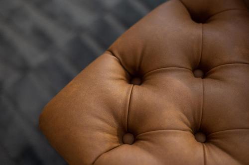 a brown leather couch with the back of it at Ferraria XVI FLH Hotels Lisboa in Lisbon