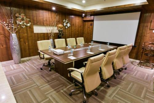 a conference room with a long table and chairs at Souvenir Jaipur in Jaipur