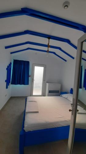 a bedroom with a blue and white bed in a room at Complex Turistic Essenza in Murighiol