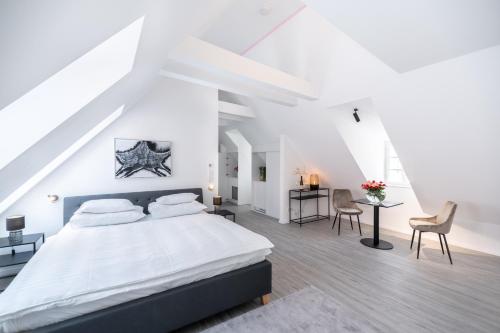 Schlafzimmer mit einem Bett, einem Schreibtisch und Stühlen in der Unterkunft Smile Apartments “Art Collection“ in Krems an der Donau