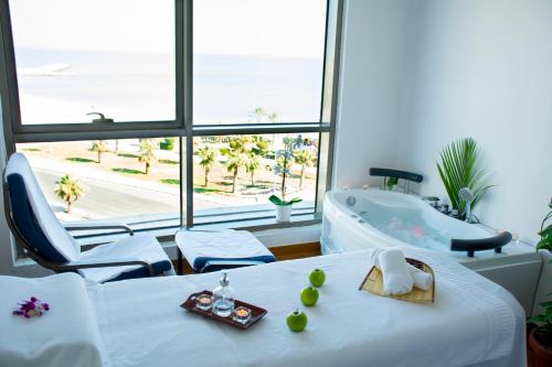 a room with a tub and a table with fruit on it at Kuwait Grand Hotel in Kuwait