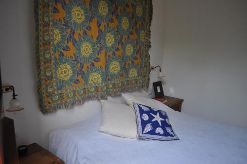 ドンナルカータにあるVilla degli Oliviのベッドルーム1室(壁にタペストリー付きのベッド1台付)