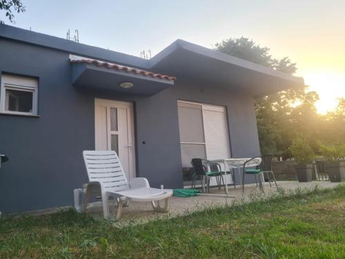 a group of chairs sitting outside of a house at Apartman Julka in Sukošan