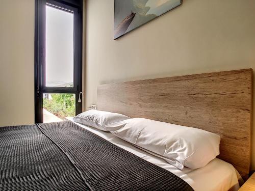 a bedroom with a bed with a wooden headboard and a window at Villas Alamos - 4509 in Mar de Cristal