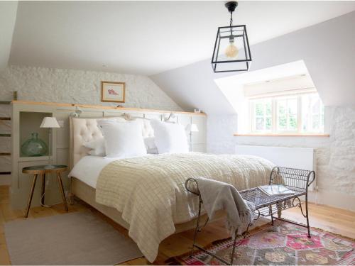a bedroom with a large bed with white pillows at Apple Store Cottage in Charlbury