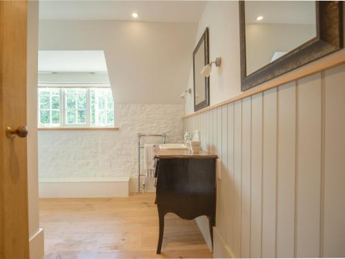 a bathroom with a sink and a mirror at Apple Store Cottage in Charlbury