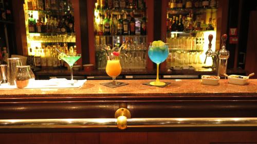 a bar with three cocktails sitting on a counter at Hotel Du Parc - Mulhouse Centre in Mulhouse