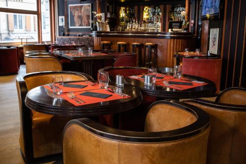 a restaurant with tables and chairs and a bar at Hotel Du Parc - Mulhouse Centre in Mulhouse