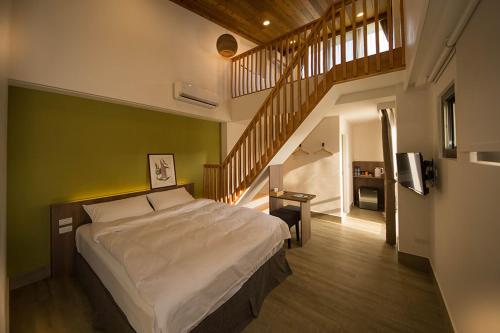 um quarto com uma cama grande e uma escada em 南窩綠丘-綠丘行旅 em Tongxiao
