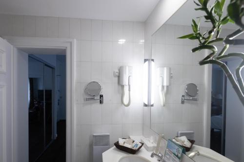 a bathroom with a sink and a mirror at Hotel Du Parc - Mulhouse Centre in Mulhouse