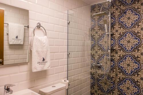 y baño con ducha, aseo y toalla. en Zouzoulas Filoxenia - Koralia Apartments, en Milina