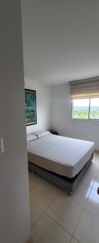 ein Schlafzimmer mit einem Bett in einem Zimmer mit einem Fenster in der Unterkunft LINDO APARTAMENTO AMOBLADO. in Neiva