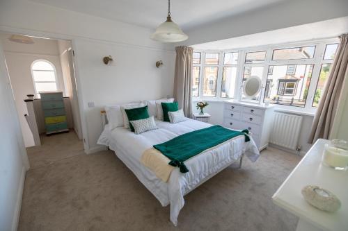 a white bedroom with a bed and a window at 'Sandy Bottom' Broadstairs by the beach in Broadstairs