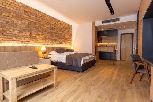 ein Schlafzimmer mit einem Bett und einer Ziegelwand in der Unterkunft Apartmoon in Sarajevo