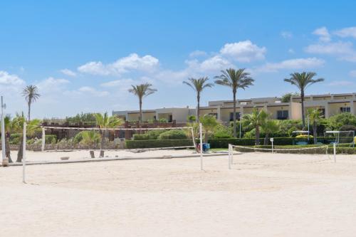 a volleyball court on the beach with palm trees at Caesar Bay Resort in Marsa Matruh