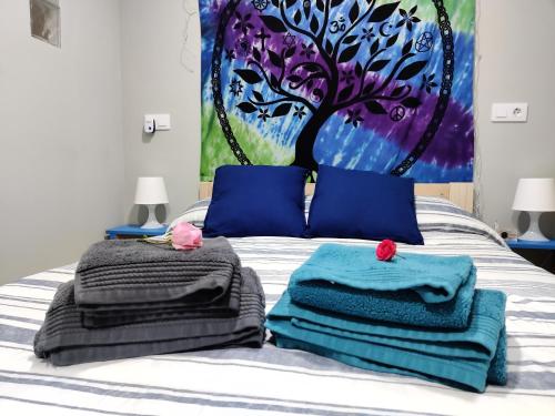 a bed with towels on it with a tree on it at La casa del abuelo Ángel in Lugo