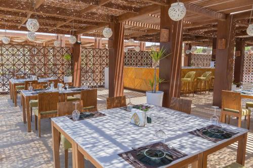 a dining room with tables and chairs in a restaurant at Caesar Bay Resort in Marsa Matruh