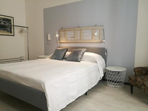 a bedroom with a large white bed and a chair at Al Campanile in Piazza Armerina