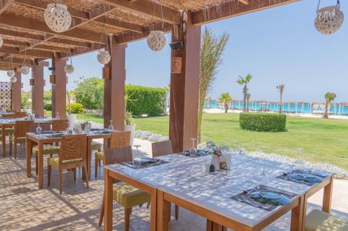a restaurant with tables and chairs under a pavilion at Caesar Bay Resort in Marsa Matruh