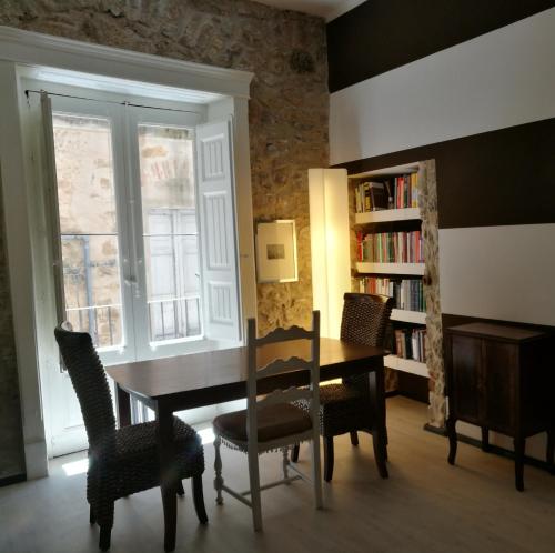 jadalnia ze stołem, krzesłami i półką na książki w obiekcie Al Campanile w mieście Piazza Armerina