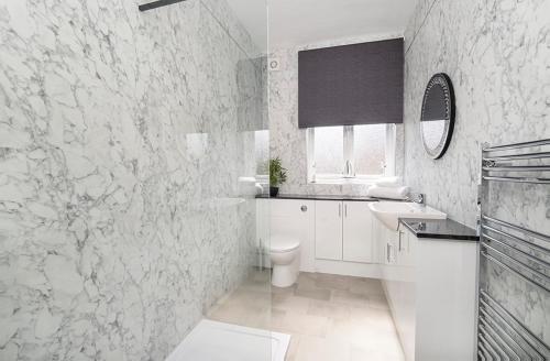a white bathroom with a toilet and a sink at 17 Penleys Grove Street in York