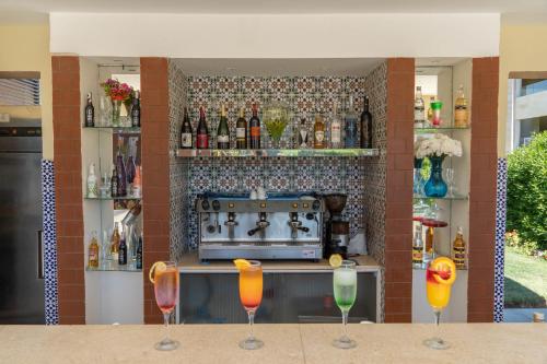 a bar with three wine glasses on a table at Caesar Bay Resort in Marsa Matruh