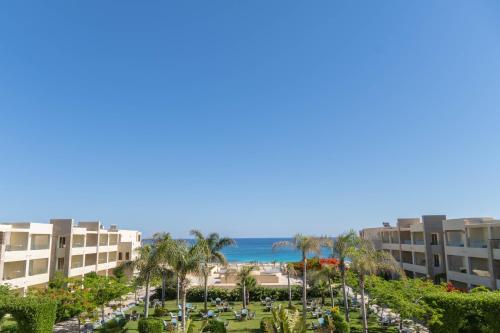 Blick auf den Strand vom Balkon eines Resorts in der Unterkunft Caesar Bay Resort in Marsa Matruh