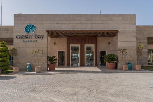 a store front of a shopping center with potted plants at Caesar Bay Resort in Marsa Matruh