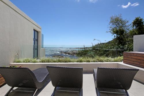 a patio with two chairs and a view of the ocean at Azamare Guest House in Cape Town