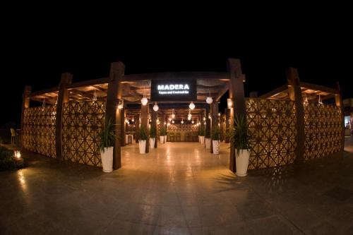 a night view of a restaurant with potted plants and lights at Caesar Bay Resort in Marsa Matruh
