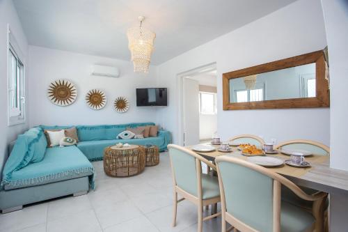 a living room with a table and a blue couch at Celini beach house in Kiotari