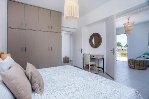 a bedroom with a bed and a table and a mirror at Celini beach house in Kiotari