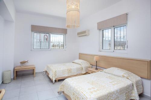 a room with two beds and two windows at Celini beach house in Kiotari