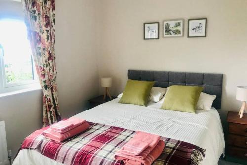 a bedroom with a bed with two pillows on it at Eden Cottage in Lisburn