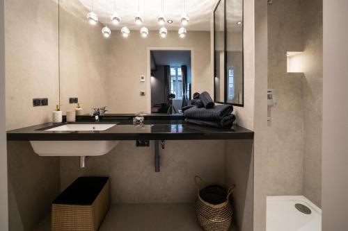 La salle de bains est pourvue d'un lavabo et d'un miroir. dans l'établissement Le Luxury Design de la Vieille Ville, à Annecy
