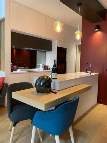 a kitchen with a wooden table and blue chairs at Le Luxury Design de la Vieille Ville in Annecy