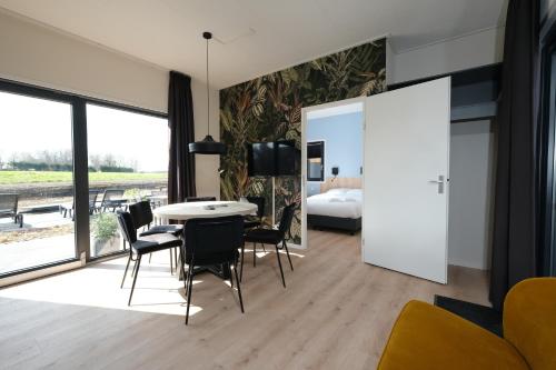 a living room with a table and chairs and a bedroom at Hofparken Wiltershaar - groepsaccommodatie met privé wellness in Kotten