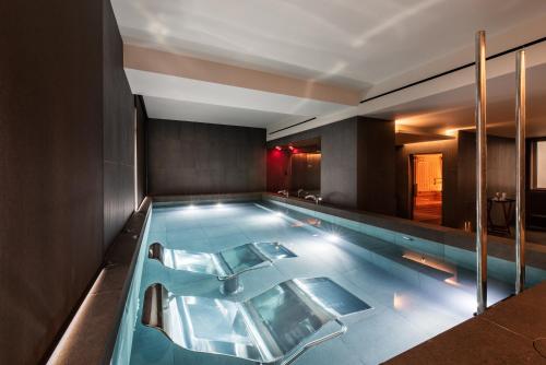 a swimming pool in a hotel room with a bathtub at Eurostars Aliados in Porto