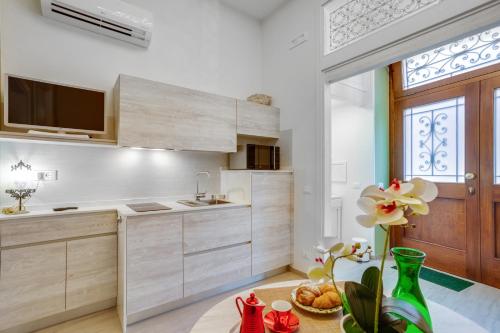 een keuken met witte kasten en een groot raam bij MADAME BARI' Suite Apt in the heart of Bari in Bari