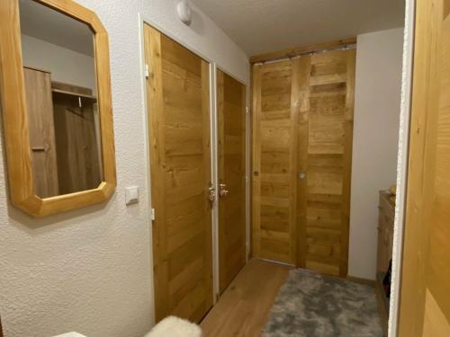 - un couloir avec des portes en bois et un miroir dans l'établissement Studio Montgenèvre, 1 pièce, 4 personnes - FR-1-445-147, à Montgenèvre