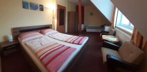 1 Schlafzimmer mit 2 Betten und einem Sofa in der Unterkunft U Rozhovoru in Rovensko pod Troskami