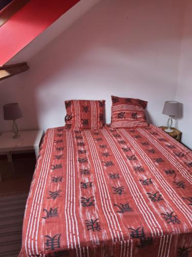 sypialnia z łóżkiem z czerwoną kołdrą i 2 lampami w obiekcie Domi et les chats w mieście Barbezières