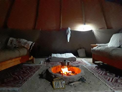 a living room with a couch and a fire pit at Otium Oasis Glamping & Camping in Hartebeest Rivier