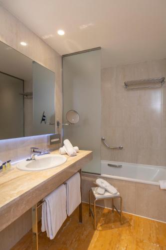 a bathroom with a sink and a tub and a mirror at Hotel BCL Levante Club & Spa 4 Sup - Only Adults Recomended in Benidorm