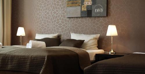 a hotel room with two beds and two lamps at Hotel Bürgerhof in Cologne