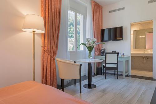 a hotel room with a table and a bedroom at Hotel Lido Seegarten in Lugano