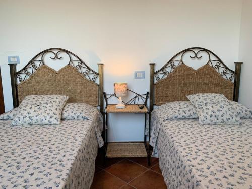 Duas camas sentadas uma ao lado da outra num quarto em Residenza Il Melograno em Budoni